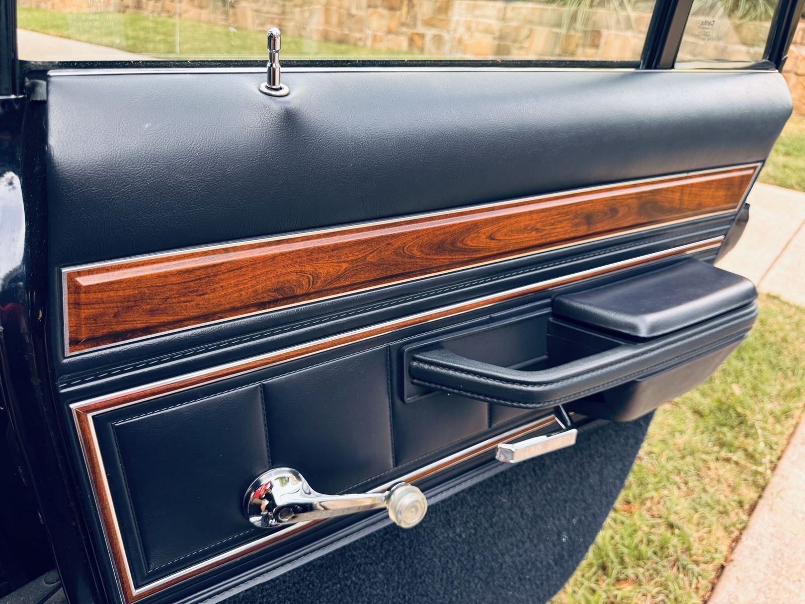 Door panel with woodgrain strip and chrome handle