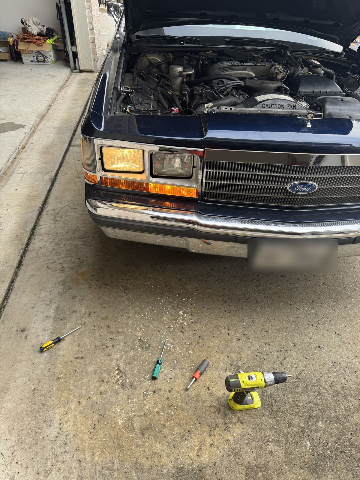 Engine bay with tools on the garage floor
