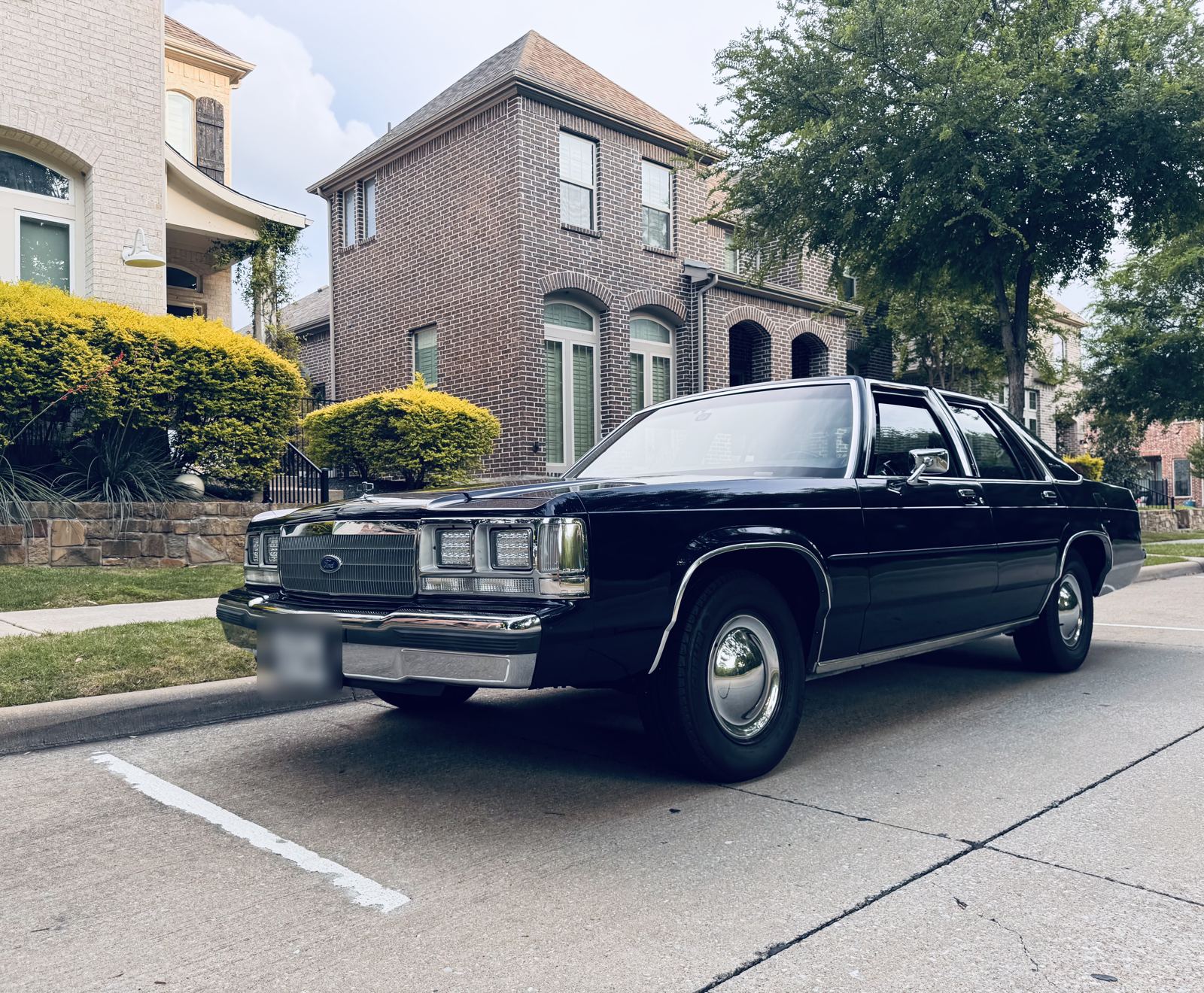 Crown Victoria parked in front of a brick house
