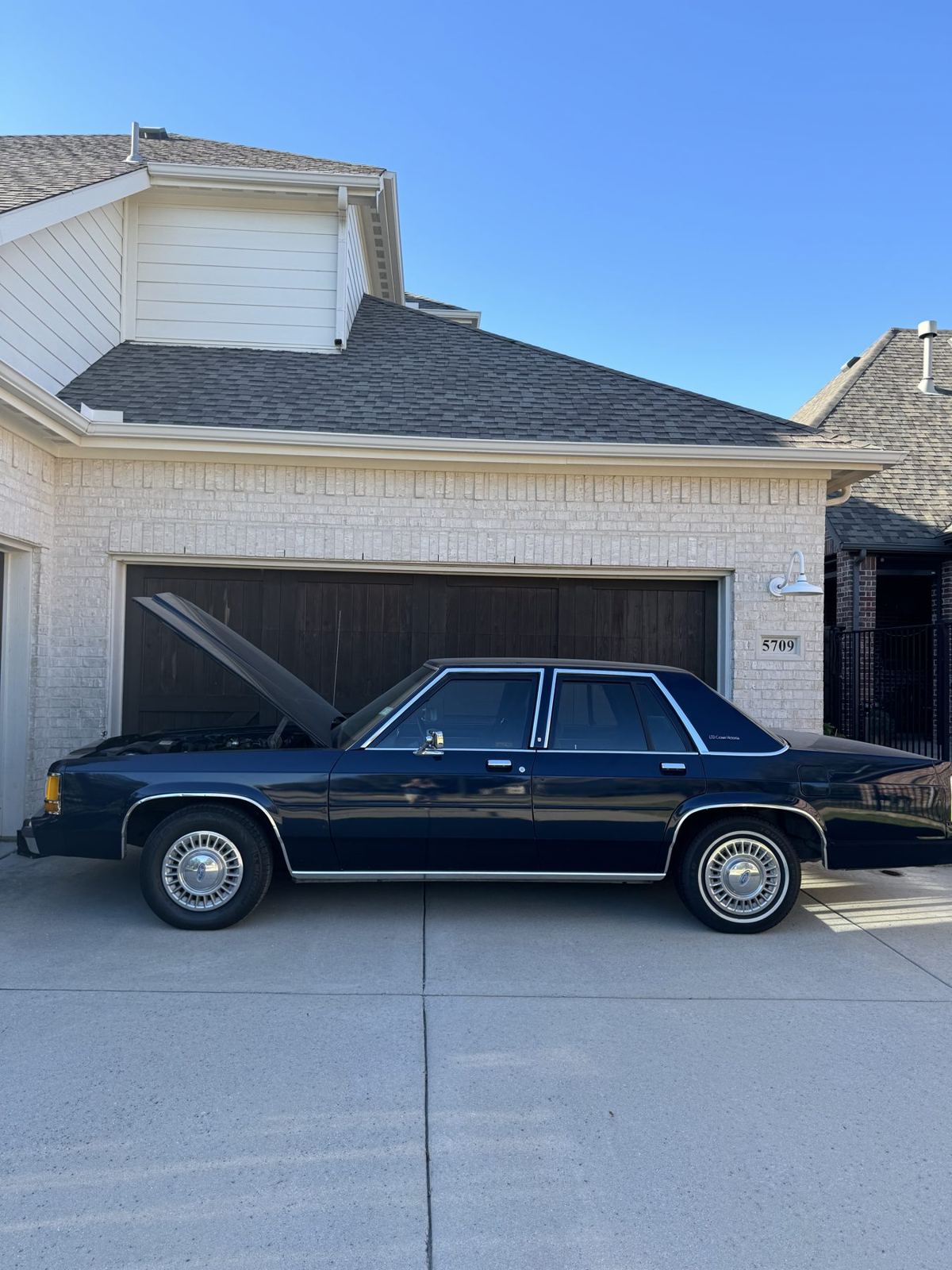 Crown Victoria in the driveway with the hood up